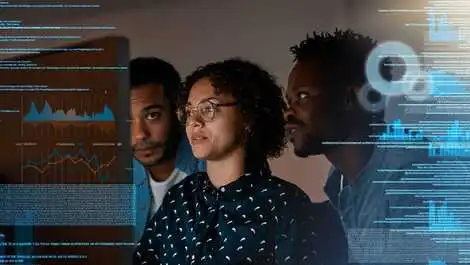 Female and male programmers working on desktop computer at night